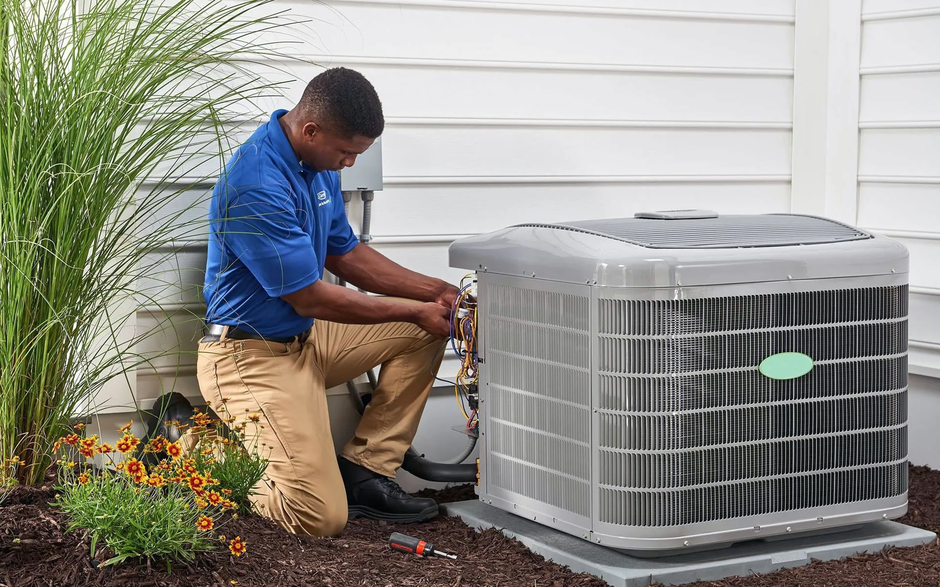 Skilled technician servicing an air conditioning unit, checking wiring and components for optimal functionality and to prevent AC breakdowns and prepare your HVAC system for weather conditions.