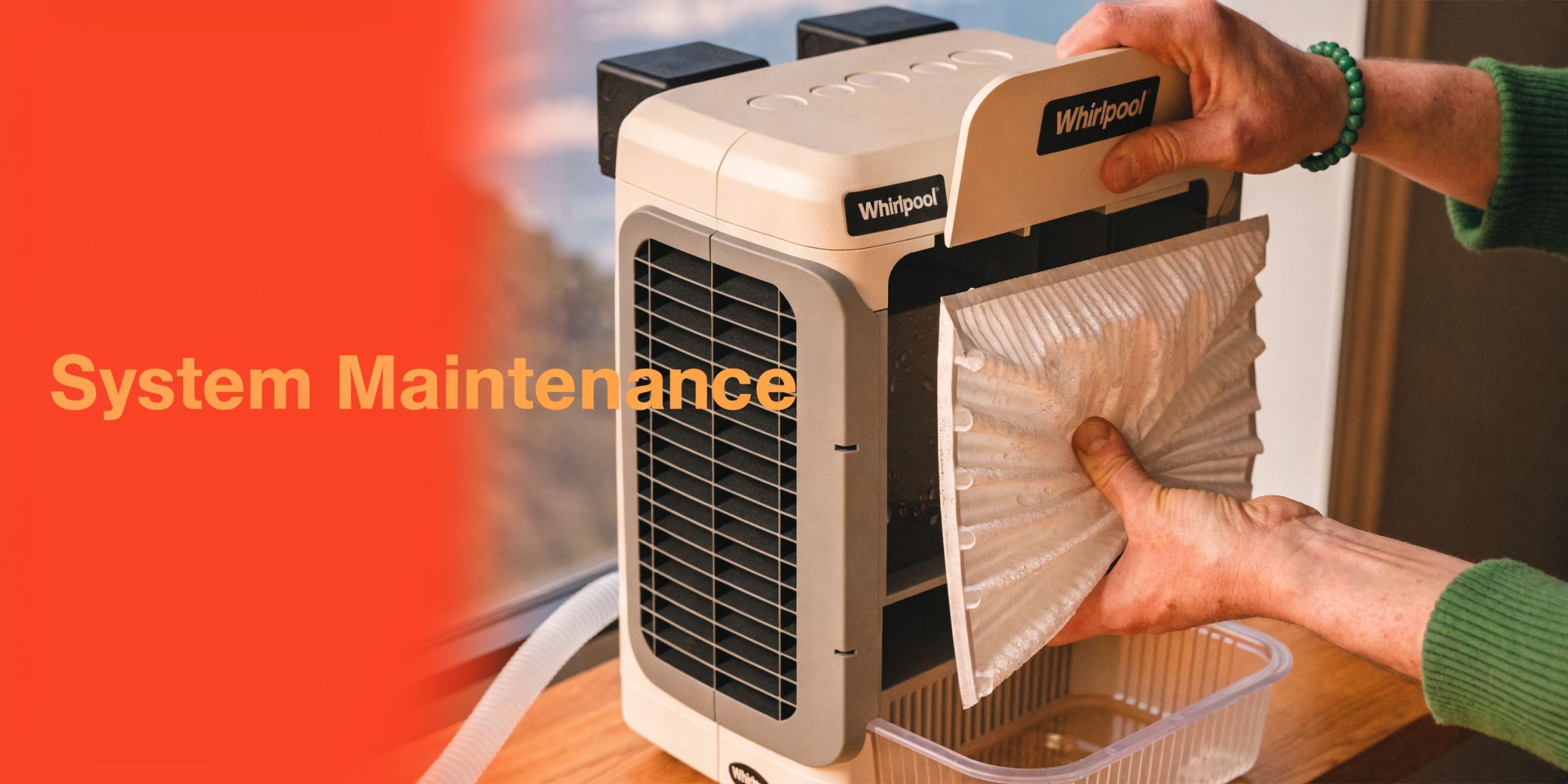 A person performing maintenance on a Whirlpool dehumidifier unit by removing the filter for cleaning.